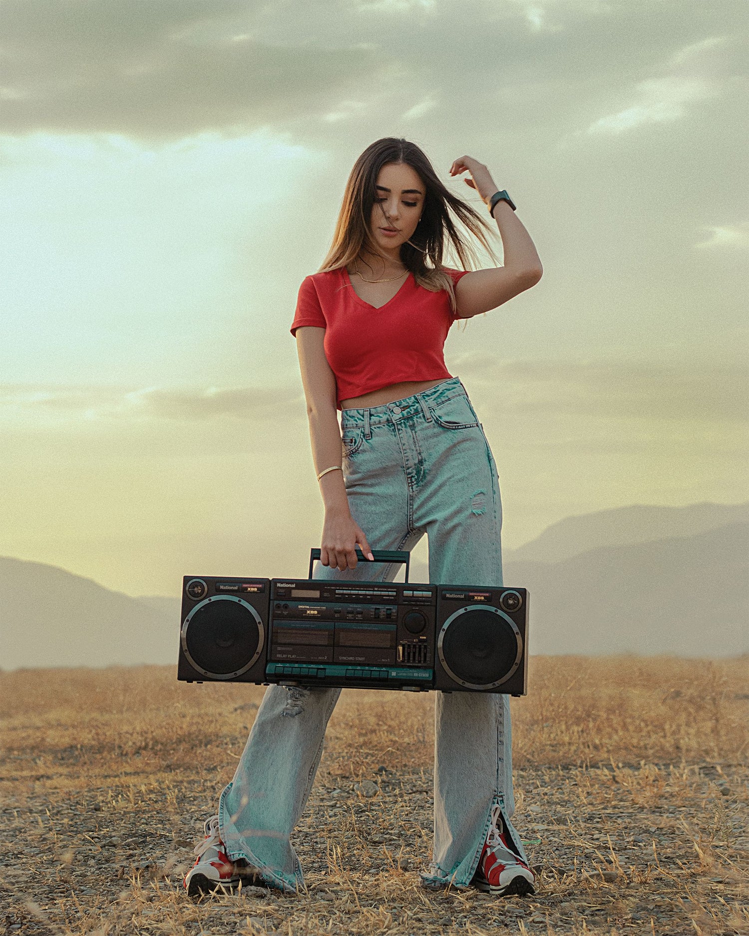 Woman in red Y2K outfit holding a boombox